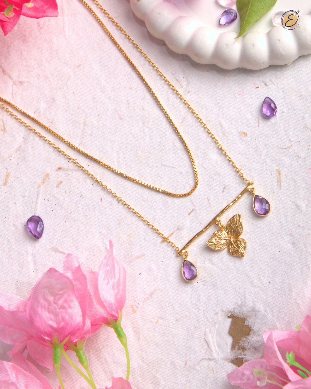 Gold-plated layered necklace with bougainvillea charm and amethyst drops.